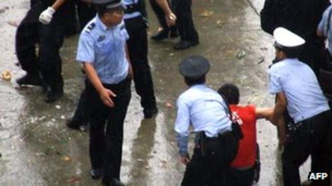 Полицейский арестовал протестующего в Личуане, провинция Хубэй, во время демонстрации с применением насилия, вызванной предполагаемой смертью местного законодателя (июнь 2011 года)