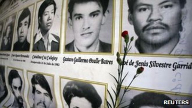 Красная гвоздика помещена рядом с фотографиями людей, погибших в 36-летней гражданской войне в Гватемале, перед церемонией, посвященной празднованию Национального дня достоинства в городе Гватемала 25 февраля 2012 года.