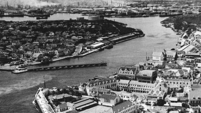 Архивная фотография Виллемстада 1940–50-х годов на фоне нефтеперерабатывающего завода. Фото предоставлено Дэном Дженсеном