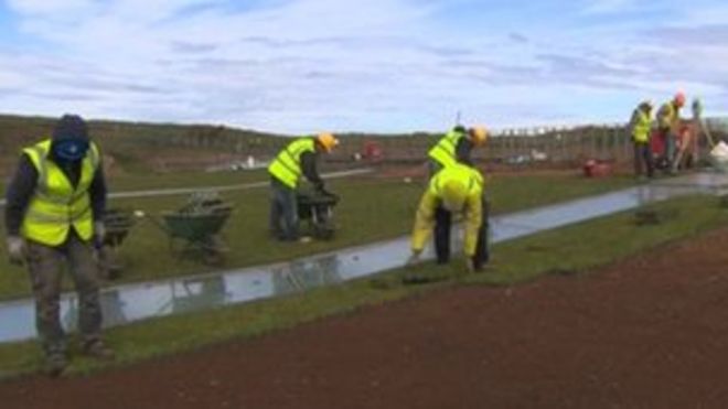 Рабочие кладут траву на крышу центра Giant's Causeway