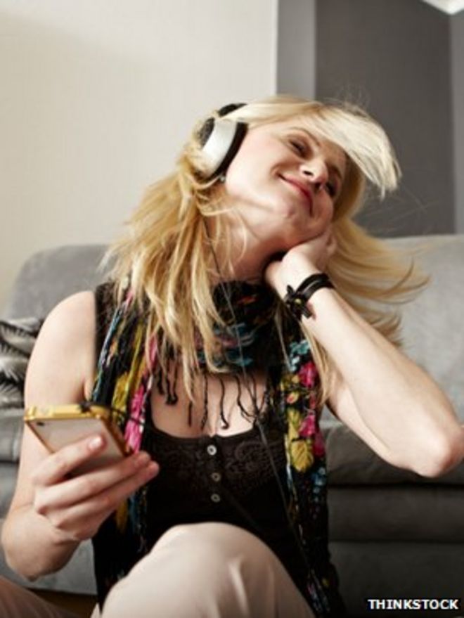 Женщина слушает музыку через смартфон