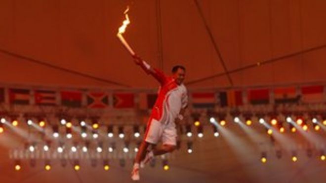 Ли Нин поднимается, чтобы зажечь Олимпийский огонь на летних Олимпийских играх 2008 года в Пекине