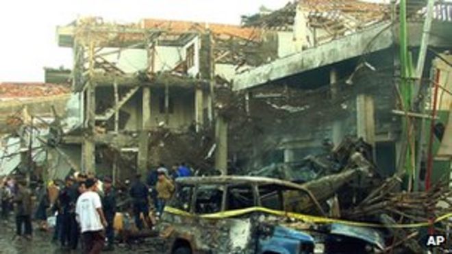 Полиция осматривает разруху в Куте, Бали, 13 октября 2002 года после нападений
