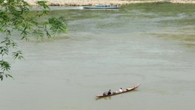 Лаосские мужчины ловят рыбу с лодки в реке Меконг в Луангпхабанге