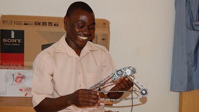 Виктор Квагга держит последний проект клуба робототехники, сделанный полностью из местных найденных материалов
