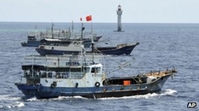 На этом фото, опубликованном китайским Синьхуа, китайские рыболовные суда проплывают мимо маяка рифа Жуби на островах Спратли в Южно-Китайском море 18 июля 2012 г.