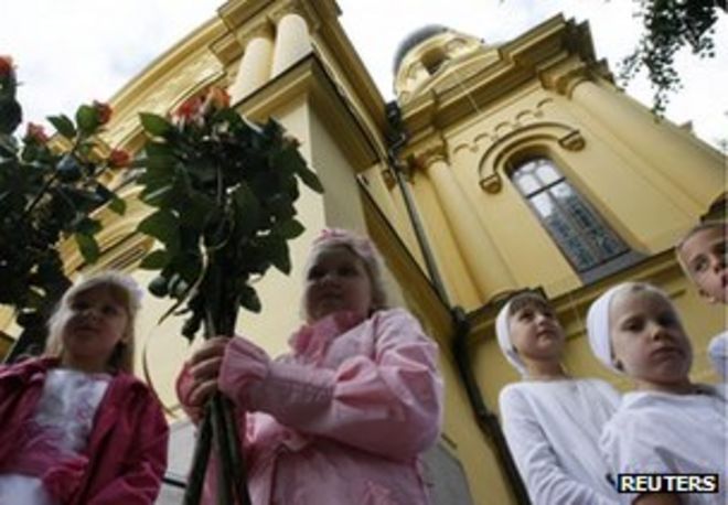 Дети православных христиан возлагают цветы в православном соборе Святой Марии Магдалины в Варшаве, 16 августа