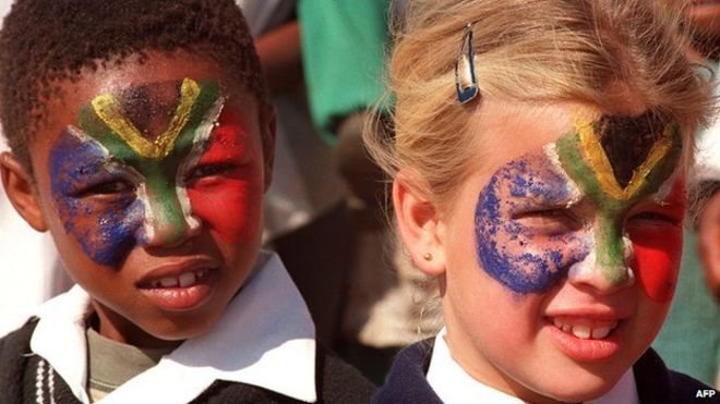 Южноафриканские девушки с лицами, раскрашенными в цвета национального флага, изображенные в 1996 году, через два года после окончания апартеида