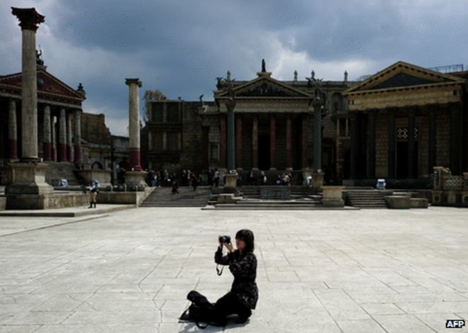 Женщина делает фотографию на съемочной площадке студии Cinecitta, изображающей древний Рим (изображение с апреля 2011 года)