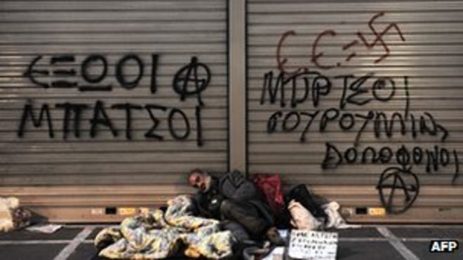 Бездомный человек спит перед закрытой витриной с надписями (23 марта, 12)