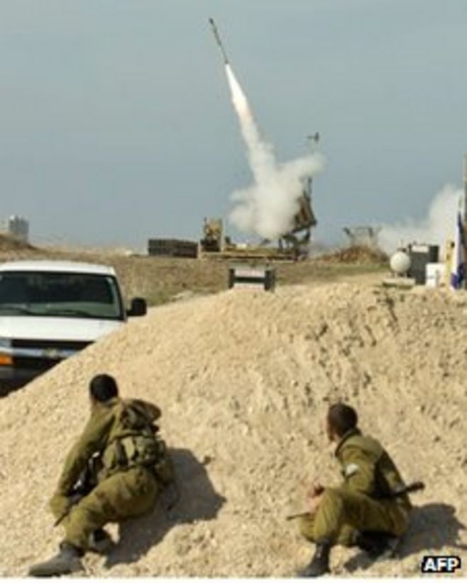 Израильские солдаты укрываются, когда израильская ракета запускается из системы ПРО "Железный купол" в южном израильском городе Ашдод, 18 ноября
