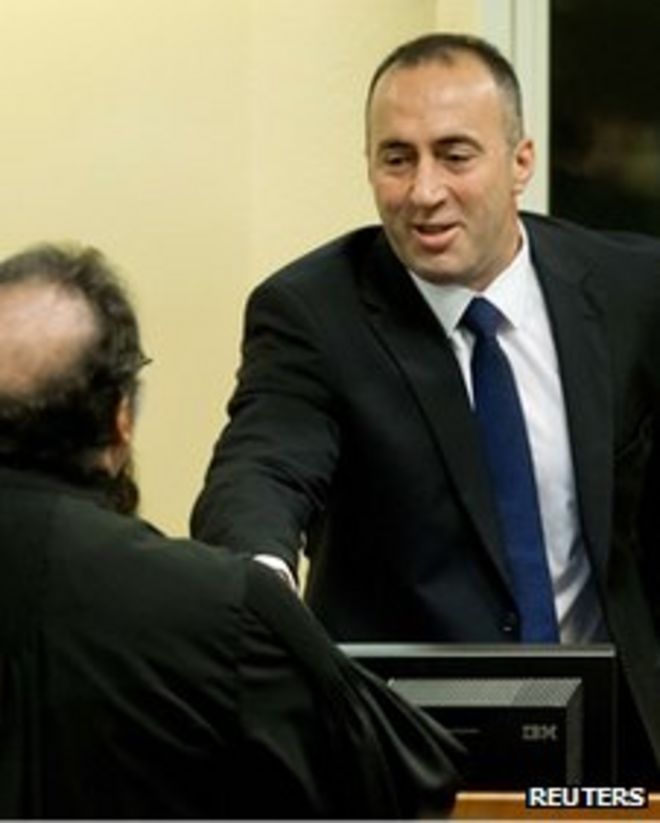 Рамуш Харадинай (справа) пожимает руку неустановленному адвокату перед вынесением приговора в ходе повторного судебного разбирательства в Международном уголовном трибунале по бывшей Югославии в Гааге, 29 ноября 2012 года