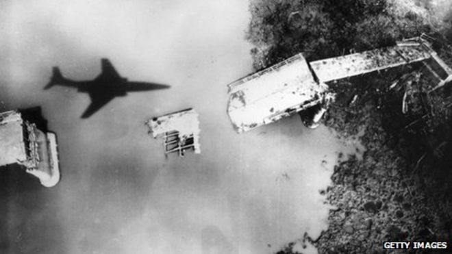 Американский самолет пролетает над разрушенным мостом в Северном Вьетнаме