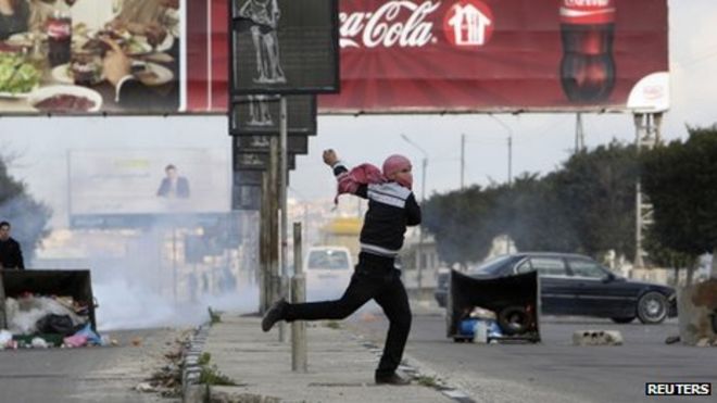 Палестинец бросает камень в израильские силы безопасности во время акции протеста в Наблусе (18 февраля 2013 года)