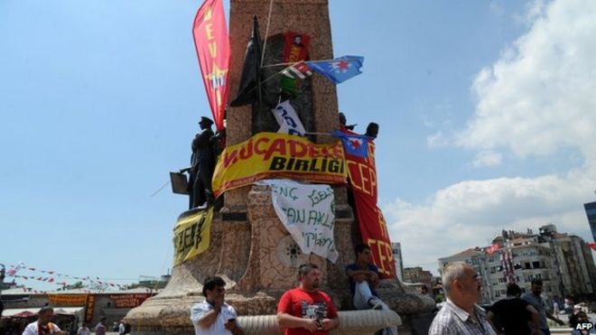 Протестующие стоят возле памятника Республики на площади Таксим в Стамбуле, 3 июня 2013 г.