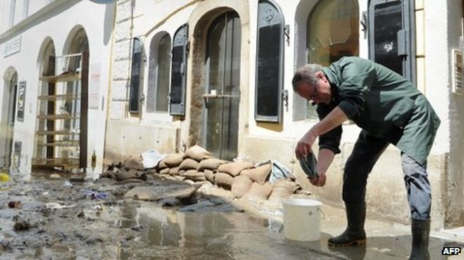 Житель убирает свой дом на улице, затопленной рекой Дунай в Пассау, на юге Германии, 5 июня 2013 года.