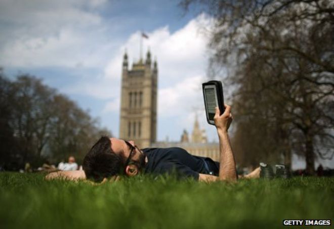 Мужчина читает электронную книгу возле парламента