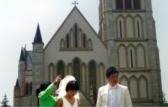 Пара позирует для свадебных фотографий перед церковью в городе Темза, Китай