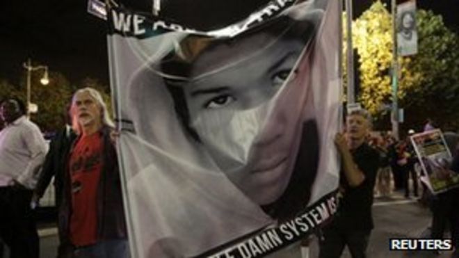 Протестующие держат изображение Трейвона Мартина в Лос-Анджелесе, 14 июля 2013 года