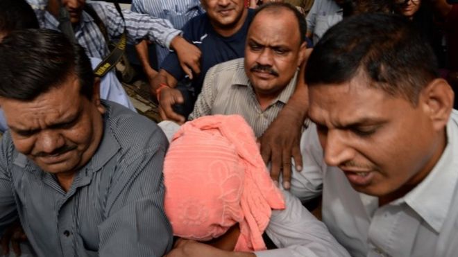 Индийские полицейские сопровождают несовершеннолетнего (С, в розовом капюшоне), обвиняемого в групповом изнасиловании в декабре 2012 года