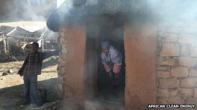 Женщина стоит в дверях дымного дома в Лесото