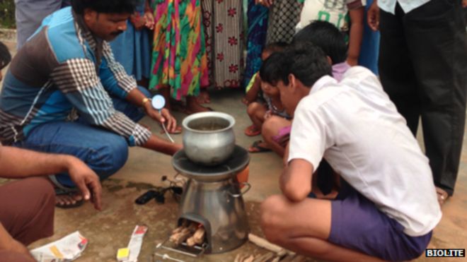 Мужчина демонстрирует бездымную кухонную плиту группе потенциальных клиентов в Индии