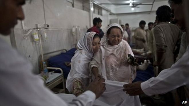 Пакистанская женщина скорбит по поводу того, как врачи прикрывают тело ее матери, убитой в результате теракта-самоубийства в церкви в Пешаваре, Пакистан, 22 сентября 2013 года