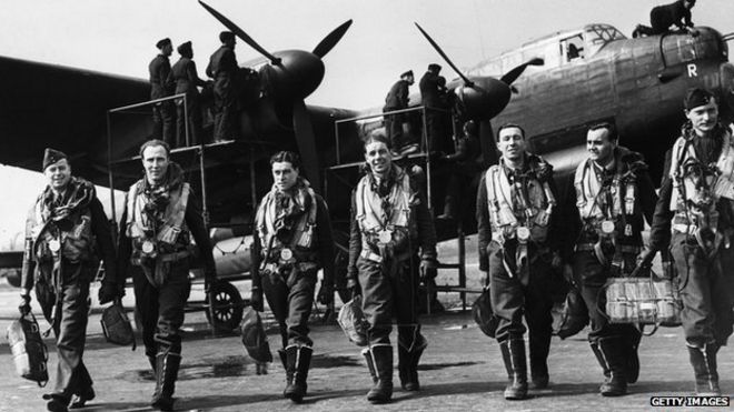 Экипаж бомбардировщика «Ланкастер» после полета покидает свой самолет, а наземный экипаж проверяет его, апрель 1943 г.