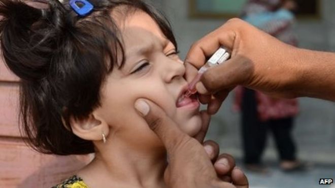 Пакистанский ребенок получает пероральную вакцину от полиомиелита во время кампании против полиомиелита в Равалпинди 1 октября 2013 года