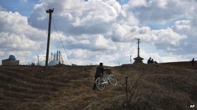 Фото из файла: Северокорейский мужчина толкает велосипед в гору на окраине Пхеньяна, 11 апреля 2013 г.