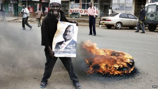 Сторонник оппозиции демонстрирует демонстрацию рядом с горящей шиной во время митинга в Элдорете в Западной Кении (16 января 2008 г.)