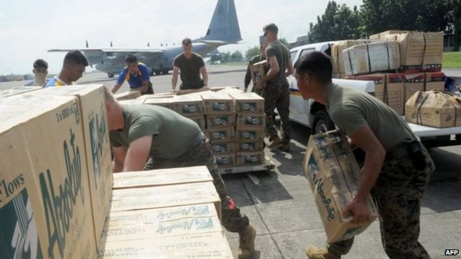Военнослужащие Филиппин и США грузят гуманитарную помощь для Таклобана на борт американского самолета C-130 для жертв супертайфуна Хайян, обрушившегося на центральную часть Филиппин, на военной базе в Маниле 11 ноября 2013 года