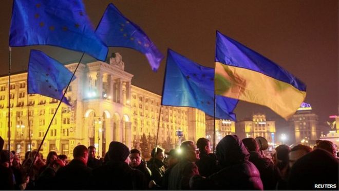 Протестующие держат флаги Украины и Европейского Союза во время митинга в поддержку евроинтеграции в центре Киева, 21 ноября 2013 года