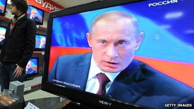 Президент России Владимир Путин появляется по телевизору в магазине электроники.