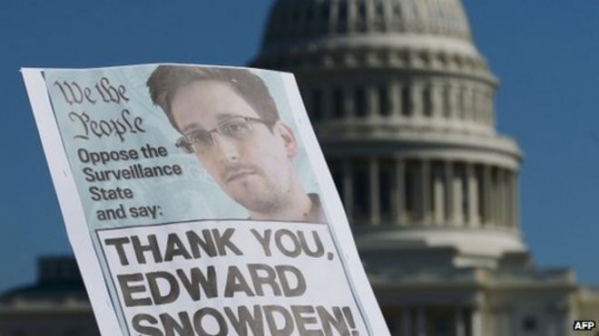 На этом фото, сделанном 26 октября 2013 года, демонстранты держат плакаты в поддержку бывшего аналитика американской разведки Эдварда Сноудена во время акции протеста против правительственного наблюдения в Вашингтоне, округ Колумбия