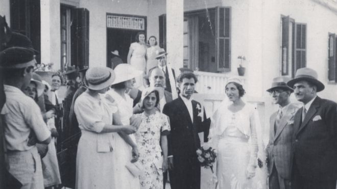 черно-белая фотография свадебной вечеринки перед домом