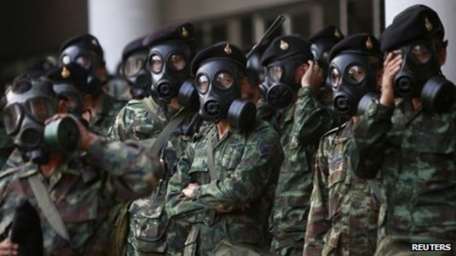Солдаты в противогазах стоят на страже на тайско-японском молодежном стадионе в центре Бангкока, 26 декабря 2013 г.