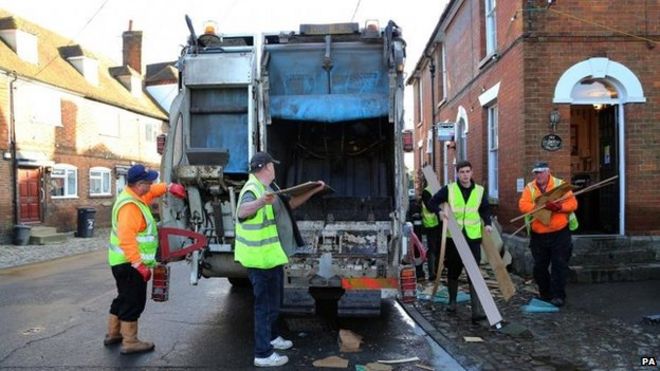 Рабочие убирают мусор из домов в Ялдинге, штат Кент, после того, как он был затоплен во время недавней непогоды.