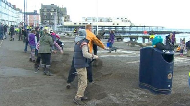 Волонтеры убираются на поврежденной штормом набережной Аберистуита