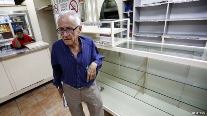 Мужчина реагирует после того, как 14 января 2014 года он обнаружил, что все полки в пекарне в Каракасе пусты.