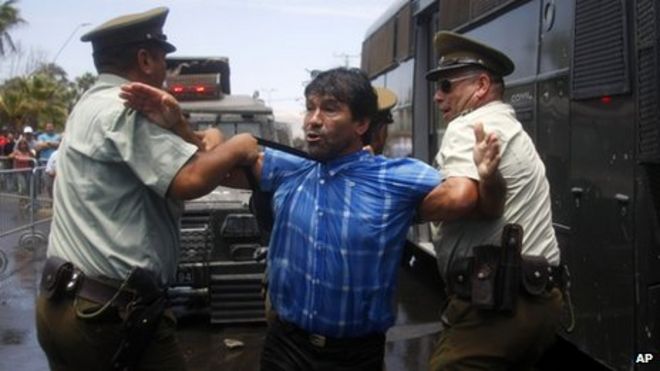 Мужчина, протестующий против решения Международного Суда относительно морской границы между Перу и Чили, задержан полицией возле военной установки в Арике, Чили, 27 января 2014 года