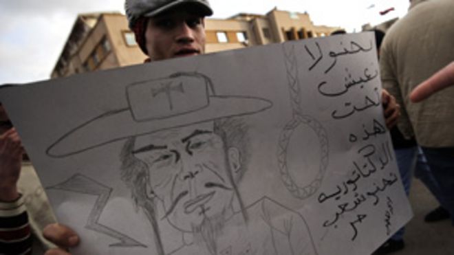 Протестующий в Бенгази с мультяшным Гадаффи