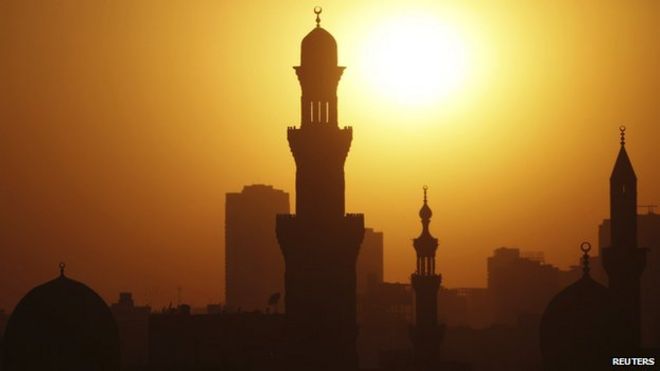 Солнце садится над минаретами мечетей в 12-й день священного поста в месяц Рамадан в Старом Каире (21 июля 2013 г.)