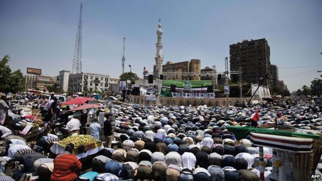 Тысячи исламистов и сторонников «Братьев-мусульман» проводят пятничные молитвы, когда они собираются в мечети Рабаа-эль-Адавия, чтобы начать открытую сидячую забастовку в поддержку легитимности президента Мухаммеда Мурси в Каире (28 июня 2013 г.)