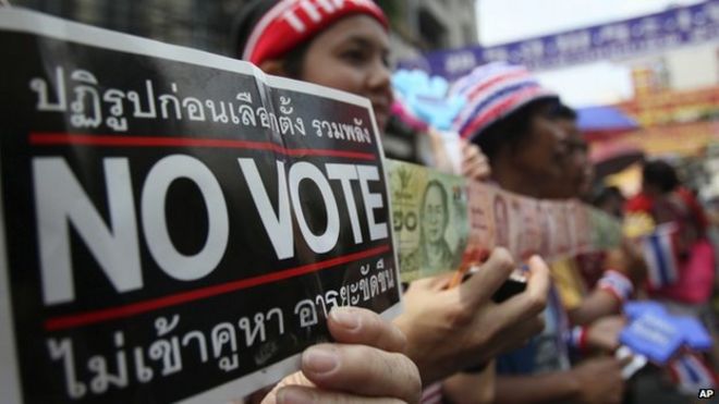 Антиправительственные демонстранты держат в Бангкоке таблички «без права голоса» (1 февраля 2014 года)