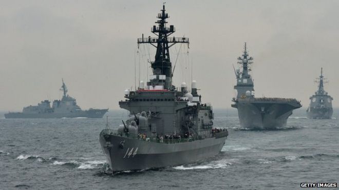 Японские морские силы самообороны сопровождают суда, принимающие участие в обзоре флота у залива Сагами, недалеко от Токио, в октябре 2012 года