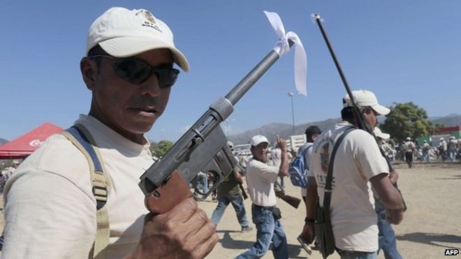 Вооруженные жители принимают участие в шествии, посвященном первой годовщине формирования групп гражданского общества, в Аютла-де-лос-Либрес, 5 января 2014 года, в юго-восточном штате Герреро, Мексика