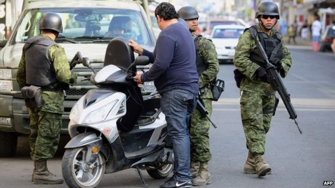 16 января 2014 года мексиканские солдаты осматривают мотоциклиста в Апацингане, штат Мичоакан.