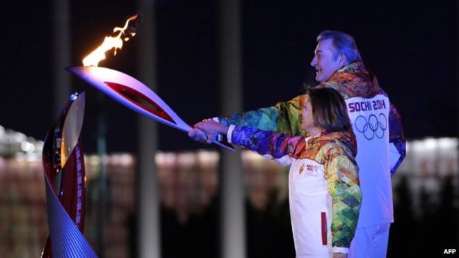 Российские факелоносцы Ирина Роднина и Владислав Третьяк готовятся зажечь Олимпийский котел на церемонии открытия зимних Олимпийских игр 2014 года 7 февраля 2014 года в Сочи.