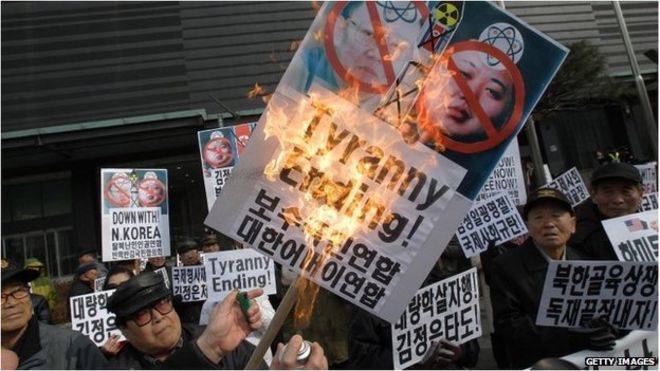 Южнокорейские протестующие сжигают анти-северокорейские плакаты во время акции протеста по случаю дня рождения Ким Чен Ира 16 февраля